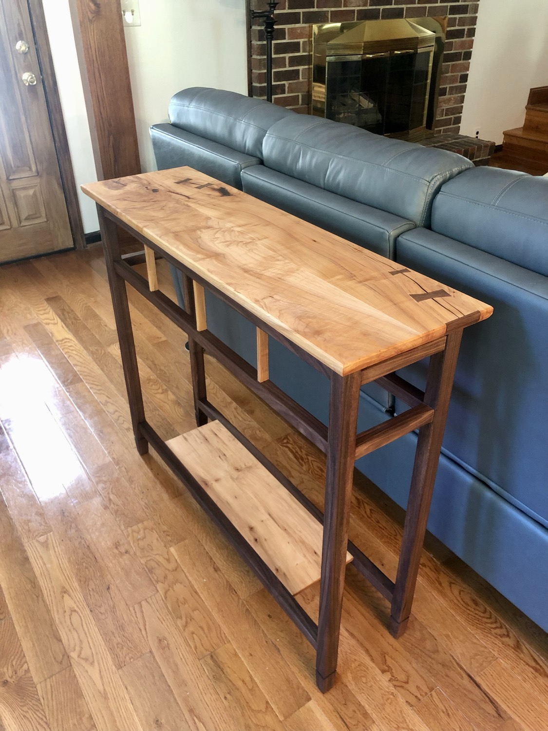 Narrow entry console table with a live-edge maple top and walnut frame