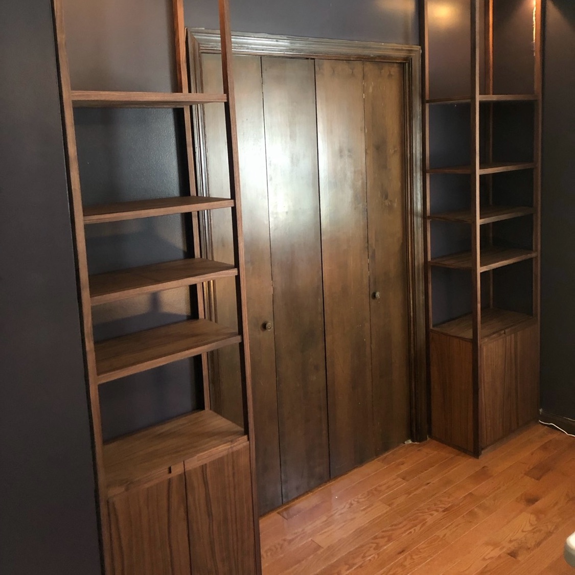 Pair of walnut shelving units flanking a closet