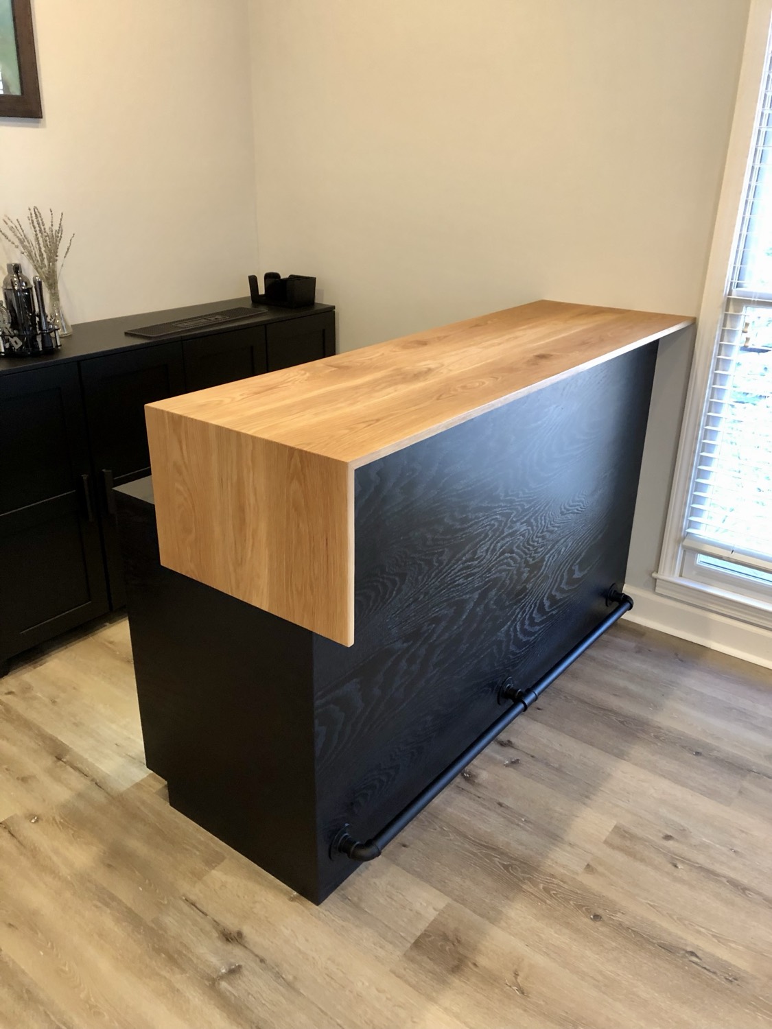 Modern waterfall-edge bar console in black and light oak